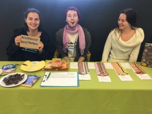 Drei Aktive hinter einem Stand der ASS mit veganen Kostproben.